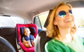 Young mother with her little baby boy in the car – cheap car insurance.