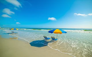 Parasols and beach chairs in Daytona Beach foreshore. Florida, USA – Daytona Beach, cheap car insurance in Florida